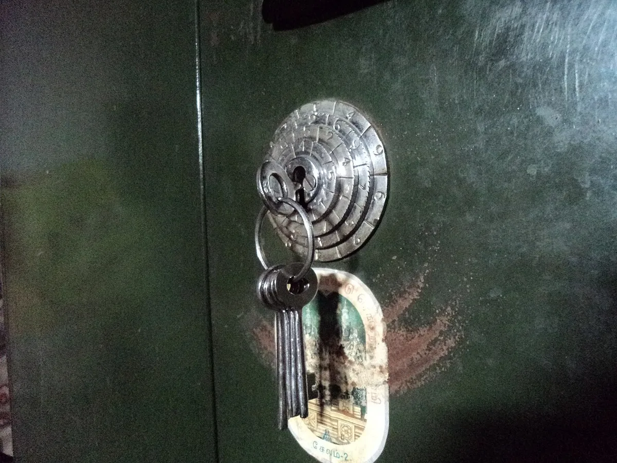 Een grote bos oude sleutels van verschillende vorm en formaat aan een metalen ring, liggend in een hand.